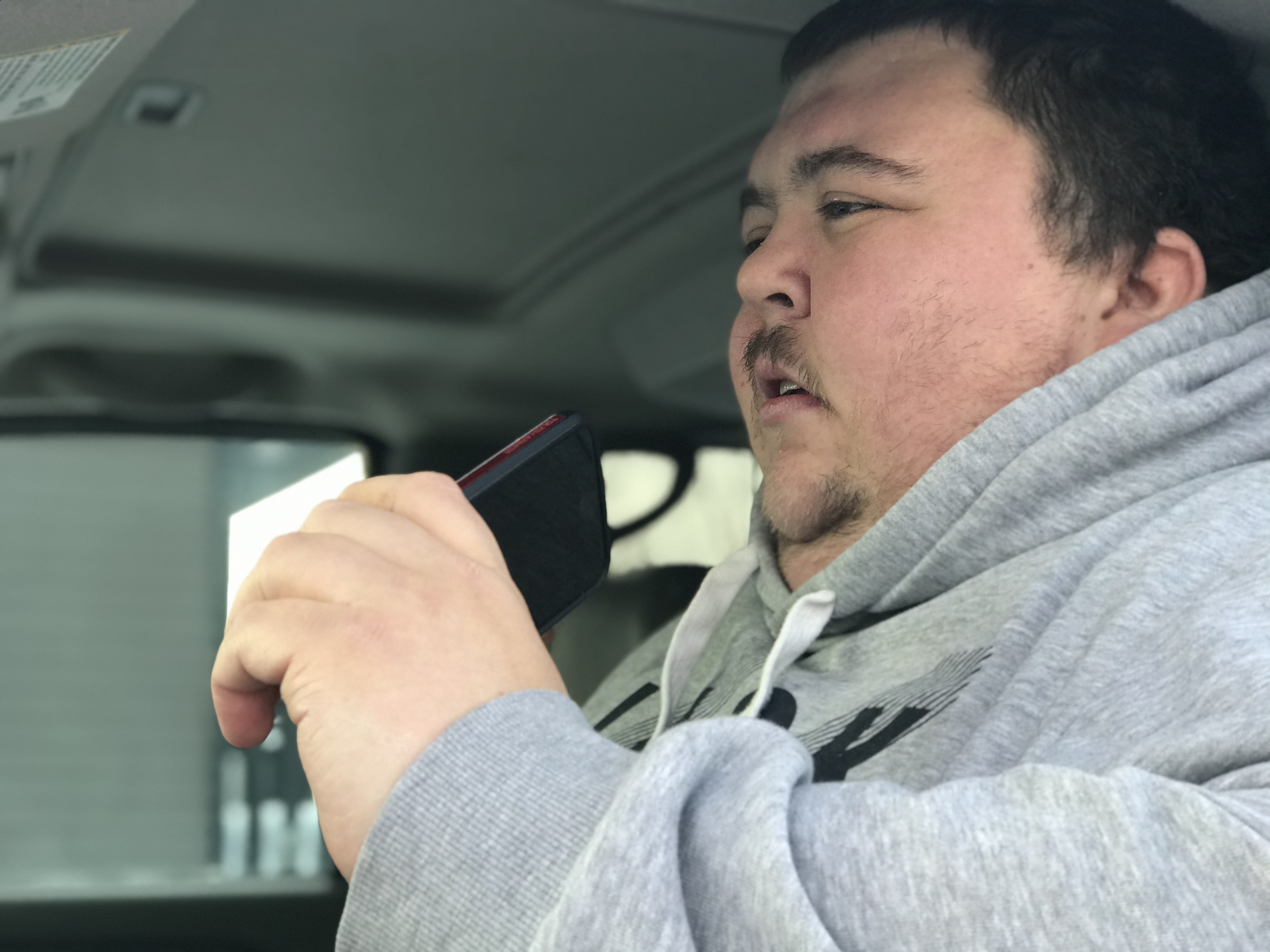 Ryan Shank on the phone in his SUV, the base of his new business. (Anna Desmarais/CBC)
